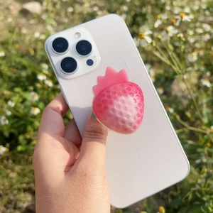 Macro view of 3D resin strawberry phone grip with gradient colors on a white phone
