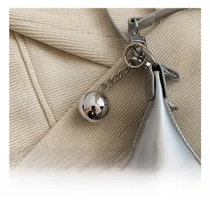 Détail du sac pois argenté avec breloque boule en métal poli et chaîne brillante