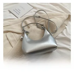 Détails du sac croissant argenté brillant avec pendentif sphérique et bandoulière fine