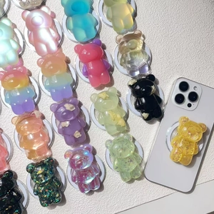 Macro shot of colorful gummy bear phone grips showing various gradient and glitter finishes