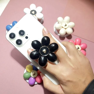3D flower phone socket holder with black glossy petals and golden heart center detail