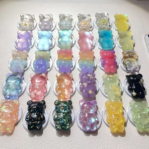 Flat lay of multiple colorful resin bear phone grip stands in a grid pattern layout