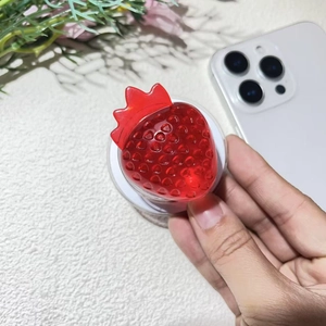 Detail of red strawberry resin phone grip with 3D texture and retractable stand