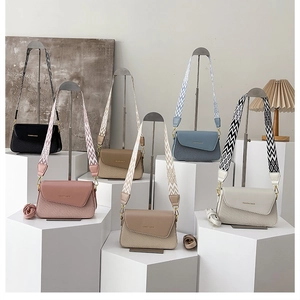Detail showing various colors of crossbody bags with patterned wide fabric straps