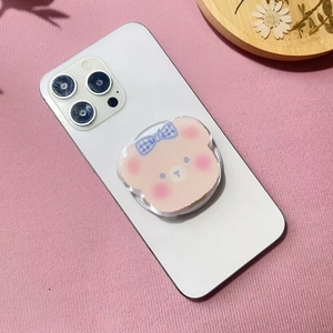 Detail of cute cartoon bear phone socket with blue bow on a white smartphone