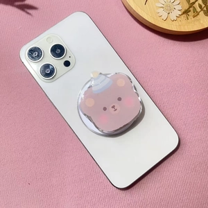 Close-up of cute acrylic brown bear magnetic phone grip with blue party hat on white phone
