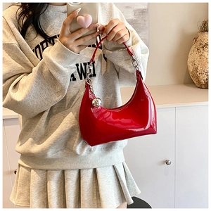 Détail du sac hobo en cuir verni rouge avec chaîne argentée et breloque sphérique
