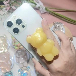 Detail of yellow gummy bear 3D phone grip holder on smartphone with glossy resin finish