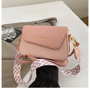 Detailed view of pink PU leather bag with woven texture and geometric patterned strap