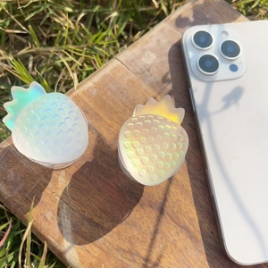 Iridescent strawberry phone sockets set on wood with natural sunlight and outdoor grass
