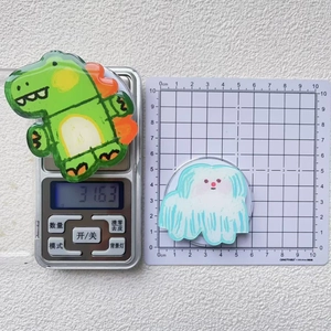 Detailed view showing the weight and size of cartoon dinosaur and puppy acrylic stands