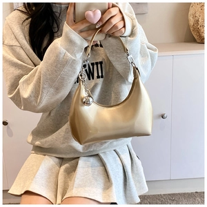 Détail du sac hobo doré champagne en cuir brillant avec pendentif sphérique argenté