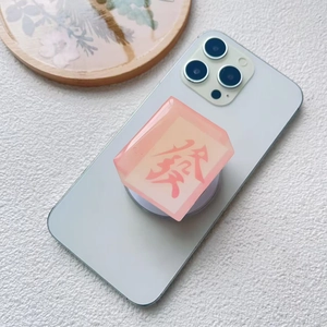 Detailed view of pink translucent resin mahjong phone socket with red character engraving