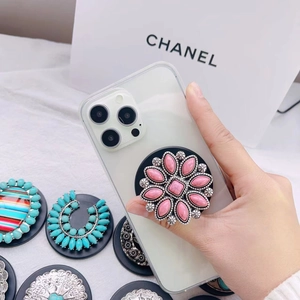 Detailed view of flower-shaped popsocket holder with pink resin gems on a gold base