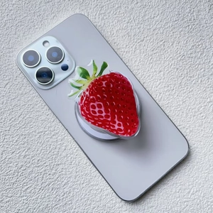 Close-up of 3D acrylic strawberry magnetic phone socket with realistic fruit texture