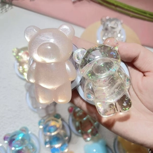 Close-up of glittery resin cartoon bear phone grips with colorful sequin details