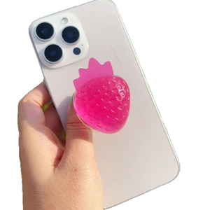 Pink resin strawberry phone grip socket with 3D texture on a white smartphone