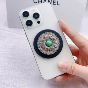 Detail of magnetic collapsible phone grip with retro turquoise stone on a white phone