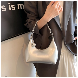 Détail du sac demi-lune argenté brillant avec poignée chaîne et pendentif boule