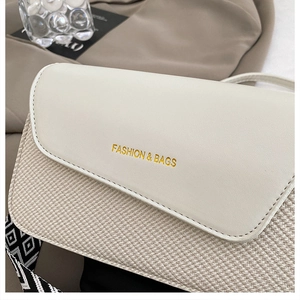 Detailed close-up of woven texture and white leather flap on the small square shoulder bag