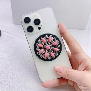 Detail of a vintage pink gemstone magnetic phone socket stand on a white smartphone
