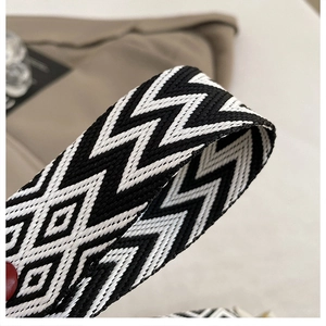 Close-up of black and white geometric woven shoulder strap with bohemian diamond pattern
