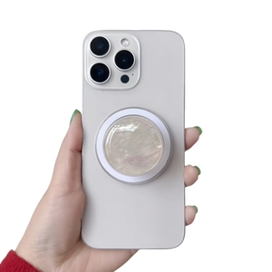 Detail of a round collapsible phone grip with mother-of-pearl texture on a smartphone