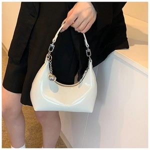 Détail du sac pois blanc brillant avec un charm boule en métal argenté et chaîne