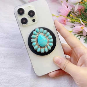 Detail of vintage turquoise MagSafe grip with retro metal border on a white smartphone