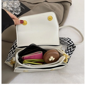 Internal view of a white flap bag with organized compartments and magnetic metal buckle