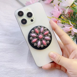 Detail view of a vintage floral pink marble phone grip stand on a white smartphone