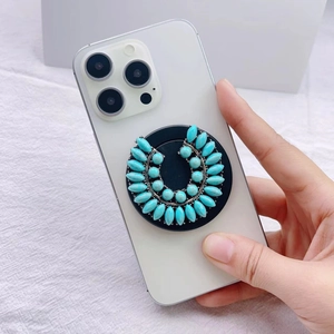 Detail of turquoise rhinestone magnetic phone socket holder on white iPhone back