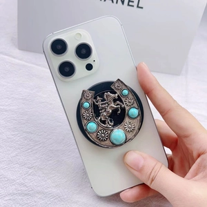 Detail showing retro silver horseshoe phone stand with turquoise and cowboy relief