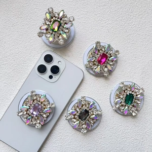 Flat lay of five colorful rhinestone MagSafe phone stands with sparkling gems