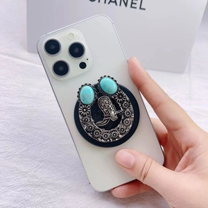 Close-up of vintage Western style magnetic phone grip with turquoise and cowboy boot relief