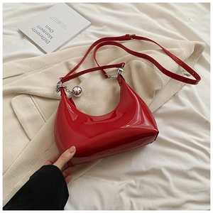 Détails du sac à bandoulière en cuir verni rouge brillant avec pendentif boule argenté