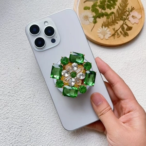 Détail du support Magsafe en cristal émeraude en forme de fleur sur un smartphone