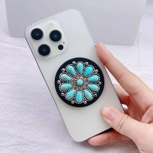 Detail of bohemian turquoise phone grip with silver beaded edge on a black base