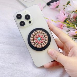 Detailed view of bohemian metal phone socket with ethnic patterns and colorful gemstones