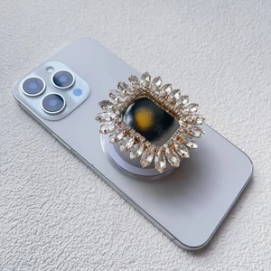 Detailansicht eines Sonnenblumen-Strass-Magnethalters auf einem lila Smartphone