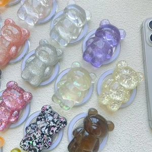 Detailed view of colorful glitter bear phone grips with various textures and finishes