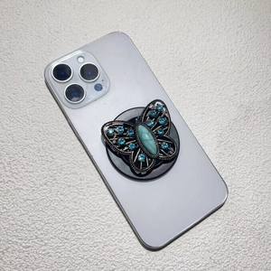 Vintage bronze butterfly phone grip featuring blue crystals and turquoise stone center