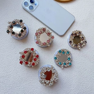 Macro shot of six rhinestone-encrusted retractable magnetic phone ring holders with mirrors