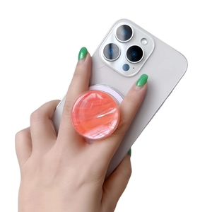 Close-up of bright orange marble pattern phone grip stand mounted on a white smartphone