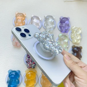 3D glitter bear phone grip stand in various colors on a white textured background