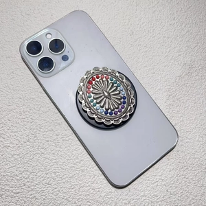 Detail of vintage bohemian phone socket with sunburst metal relief and colorful beads