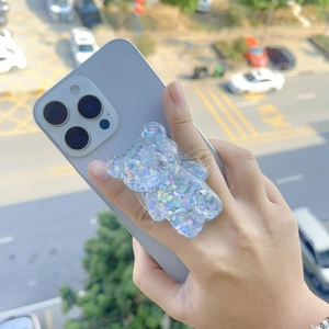 Detail of glitter-filled bear phone grip holder mounted on a purple smartphone