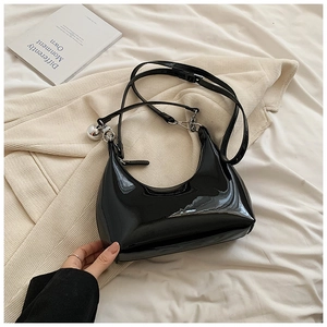 Détail du sac pois noir brillant avec breloque boule en métal argenté et bandoulière