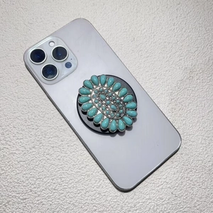 Detailed side view of a vintage turquoise teardrop stone phone grip on a smartphone