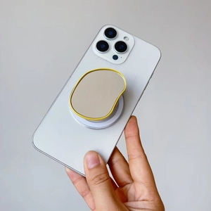 Detail of yellow bean-shaped grip tok on a white phone with a clean minimalist design